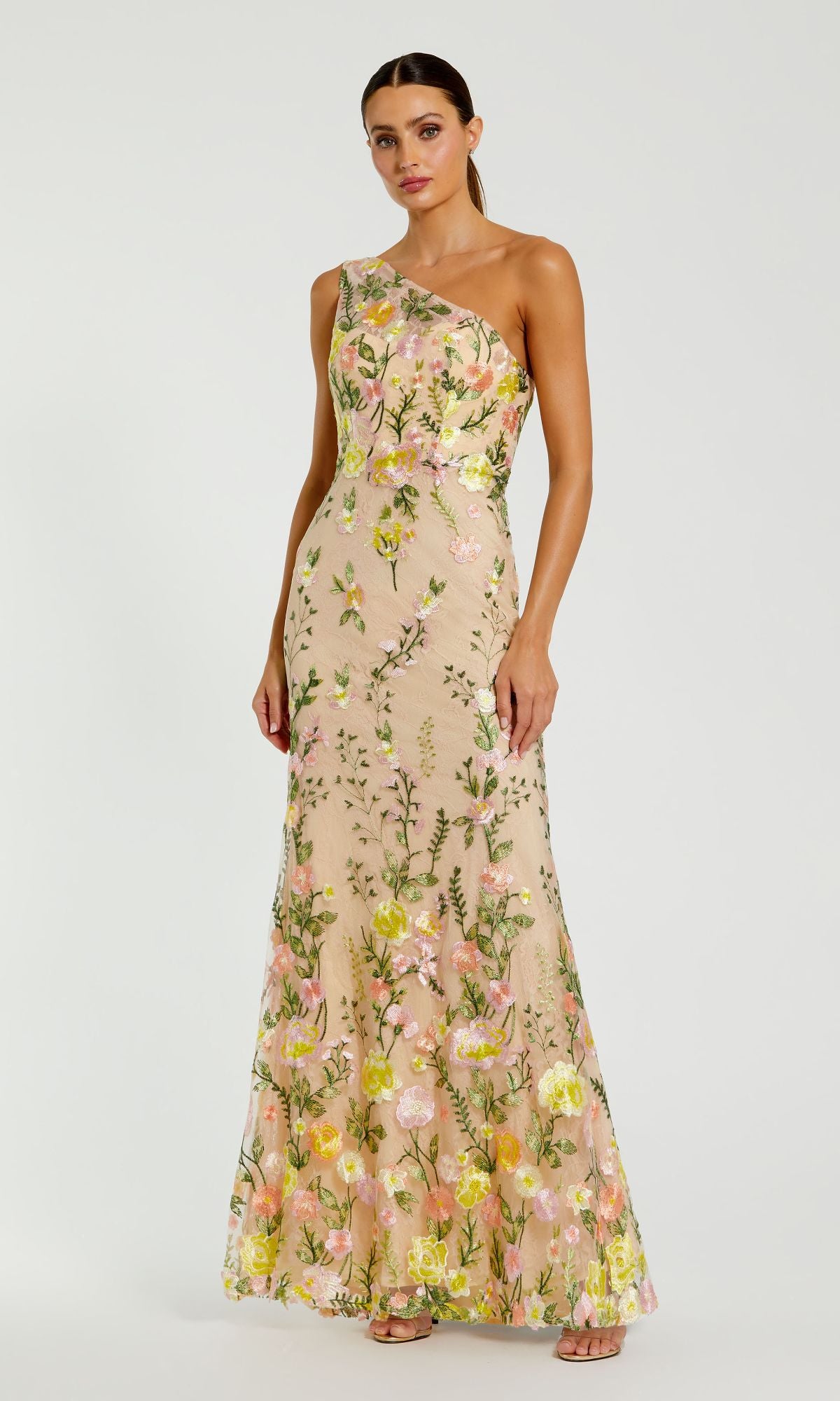 Woman wearing the Mac Duggal 68606 Yellow Floral-Print Formal Dress, featuring a long, elegant silhouette and colorful floral details, standing against a plain white background.